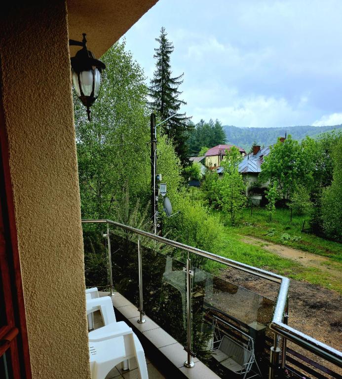 Terasa pensiunii cu vedere spre pădure și munți